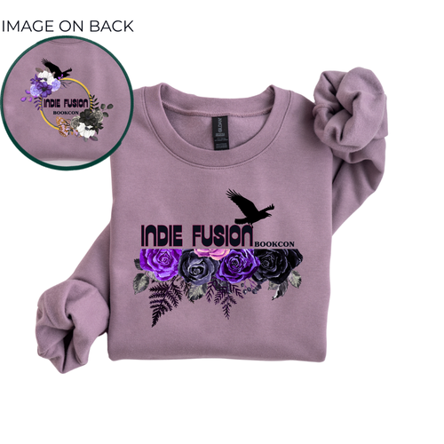 A lavender long-sleeve sweatshirt with a graphic print on the front featuring purple and black roses, a bird silhouette, and the text 'INDIE FUSION BOOKCON'. A circular inset in the top left shows the back design with a matching graphic.