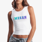 A woman wearing a white sleeveless crop tank top with the word 'HAREM' printed across the chest in reverse in a blue-to-purple gradient. She is also wearing light-wash denim jeans against a plain light gray studio background.